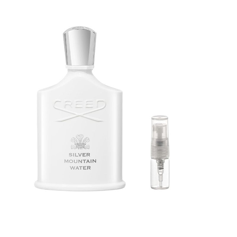 White sample perfume bottle with silver cap and small clear spray vial for sampling