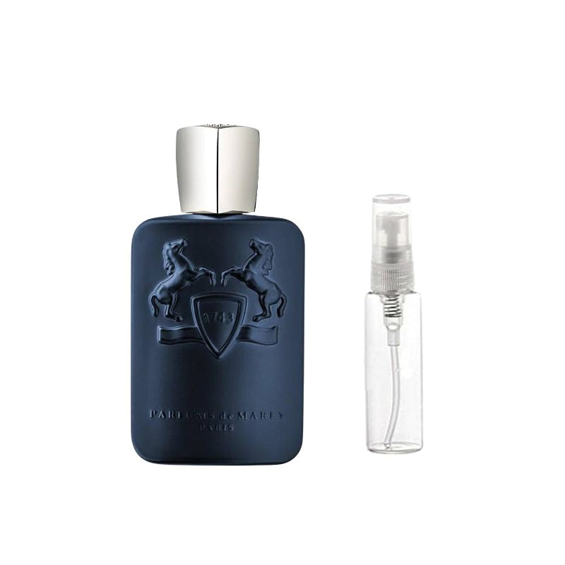 Dark blue perfume bottle with silver cap and crest, shown with clear atomizer sample vial